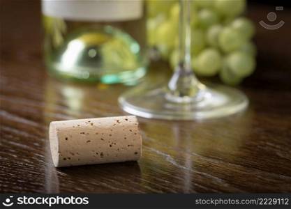 Blank Wine Cork Resting on Wood Table Near Grapes, Bottle and Glass.