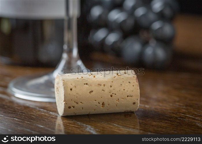Blank Wine Cork Resting on Wood Table Near Grapes, Bottle and Glass.