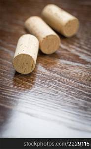 Blank Wine Corks Resting on Reflective wood Surface.
