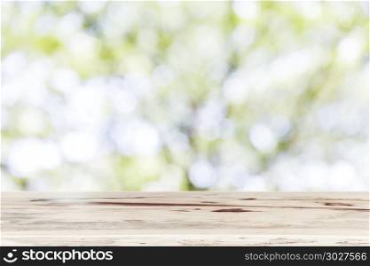 Blank wooden table top for show product with blurred natural bac. Blank wooden table top for show product with blurred natural background. Picture for add text message. Backdrop for design art work.