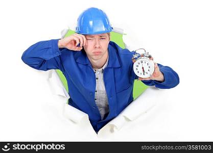 Bleary eyed construction worker with an alarm clock