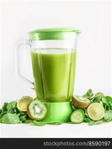 Blender with green smoothie with ingredients   kiwi, cucumber, lime and spinach at white background. Preparing healthy juice. Front view.