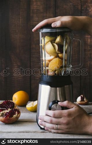 blender with various fruit wooden background