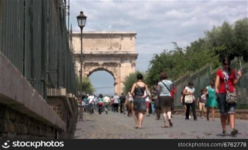 Blick auf einen Triumpfbogen in Rom mit Touristen
