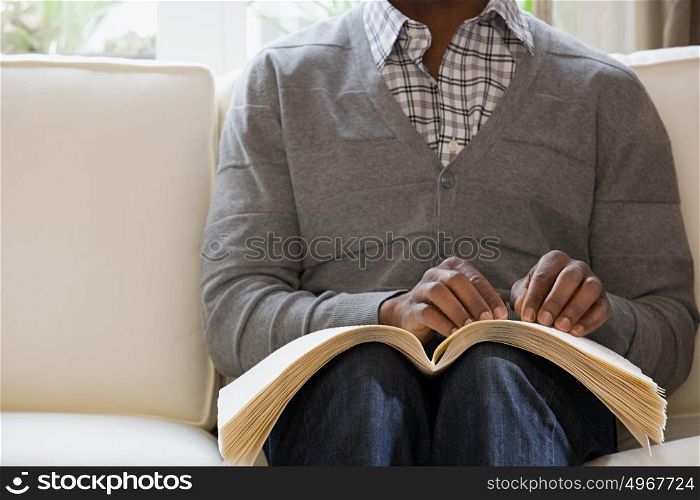 Blind man reading a braille book