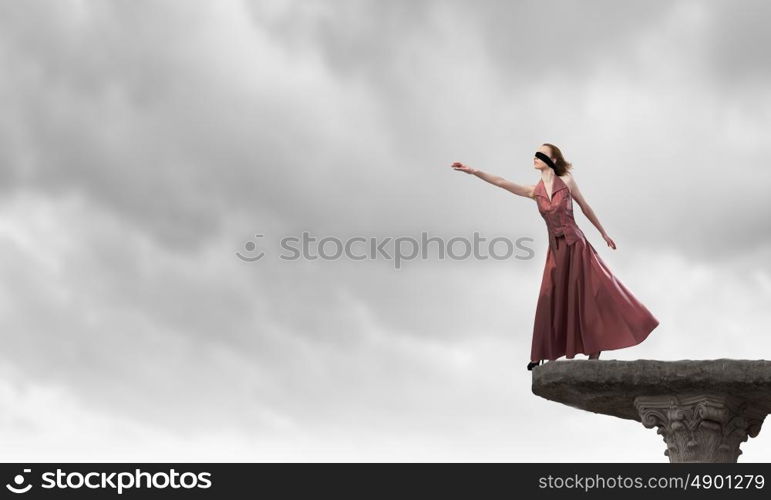 Blind woman. Young attractive woman in dress and blindfold on eyes