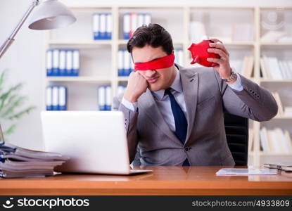 Blindfold businessman sitting at desk in office