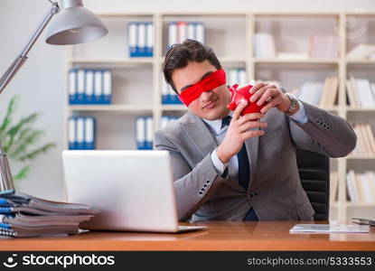 Blindfold businessman sitting at desk in office