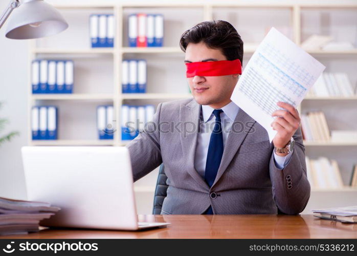 Blindfold businessman sitting at desk in office