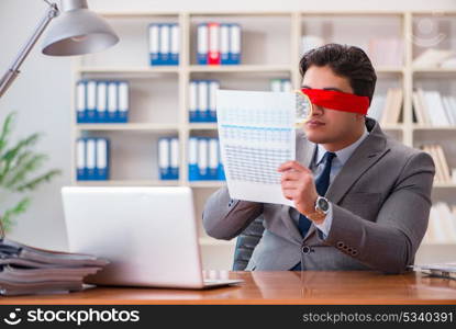 Blindfold businessman sitting at desk in office