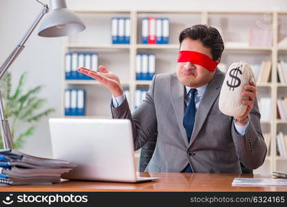 Blindfold businessman sitting at desk in office