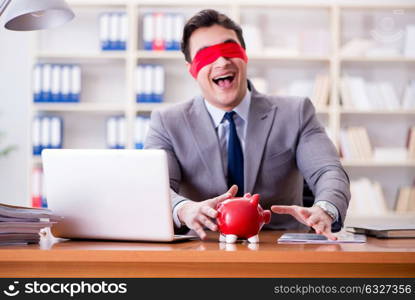 Blindfold businessman sitting at desk in office