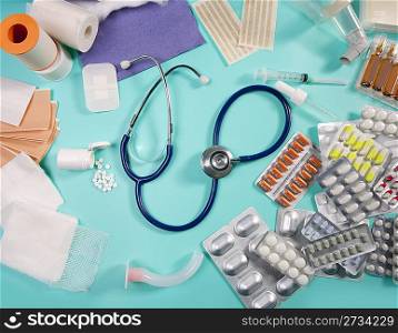 blister of medical pills and pharmaceutical stuff with stethoscope over green background