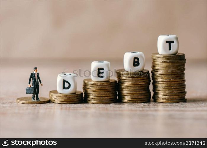 Block word debt on pile of coins with business man, Payment of taxes and of debt to the state, Concept of financial crisis and problems risk management debt exemption loan