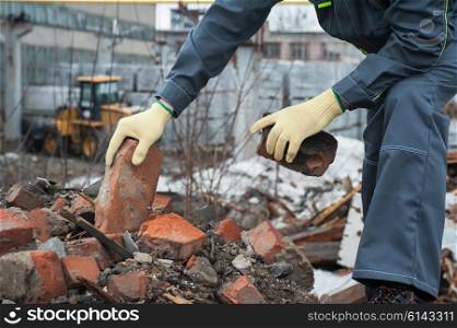 blockages of broken bricks. worker takes down blockages of broken bricks
