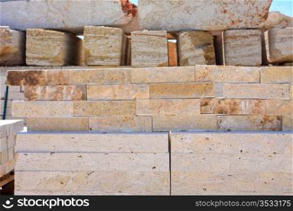 blocks of limestone processed and ready for use, are against the blue sky