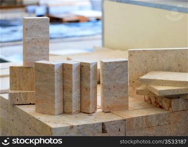 Blocks of limestone processed and ready for use, are located on the defocused background of workshop