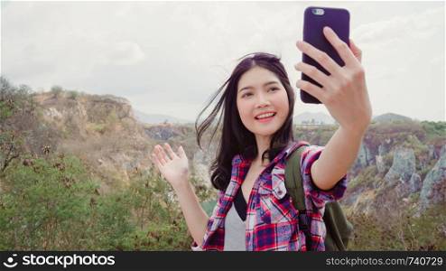 Blogger Asian backpacker woman record vlog video on top of mountain, young female happy using mobile phone make vlog video enjoy holidays on hiking adventure. Lifestyle women travel and relax concept.
