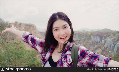 Blogger Asian backpacker woman record vlog video on top of mountain, young female happy using mobile phone make vlog video enjoy holidays on hiking adventure. Lifestyle women travel and relax concept.