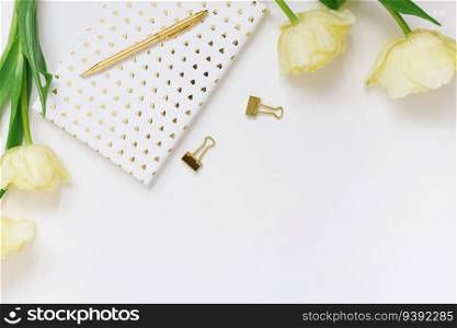 Blogger’s spring flat lay. White notepad, pen, bouquet of yellow tulips on a white background with copy space