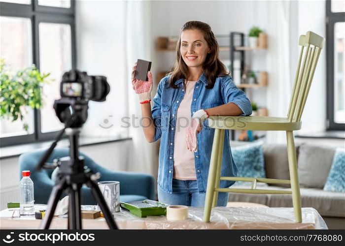 blogging, furniture restoration and home improvement concept - happy smiling woman or blogger showing sanding sponge and recording tutorial video about old wooden chair renovation. woman or blogger showing old chair renovation
