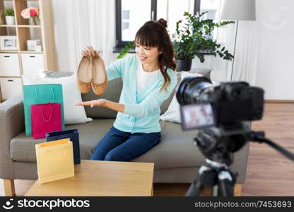 blogging, technology, videoblog and people concept - happy smiling asian woman or fashion blogger with flat shoes and camera recording video blog at home. asian female fashion blogger making video of shoes