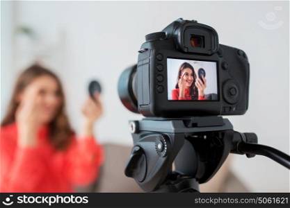 blogging, technology, videoblog and people concept - happy smiling woman or beauty blogger with eyebrow pencil, mirror and camera recording makeup tutorial video at home. woman with eyebrow pencil recording video at home