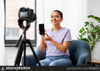 blogging, videoblog and people concept - happy smiling african american female video blogger with smartphone camera videoblogging at home. female blogger with camera video blogging at home