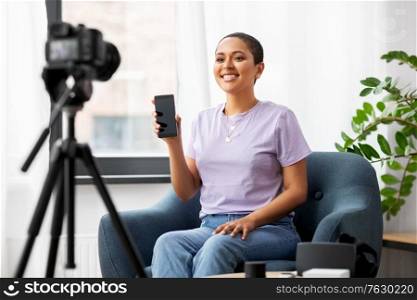 blogging, videoblog and people concept - happy smiling african american female video blogger with smartphone camera videoblogging at home. female blogger with camera video blogging at home