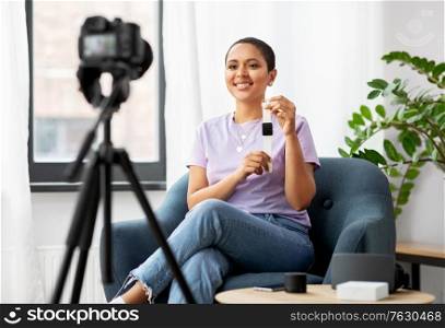 blogging, videoblog and people concept - happy smiling african american female video blogger with camera and smart watch videoblogging at home. female blogger with camera video blogging at home