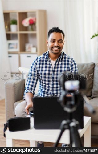 blogging, videoblog and people concept - indian male blogger with camera recording video at home. male blogger with camera videoblogging at home
