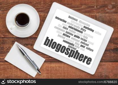 blogosphere word cloud on a digital tablet with a cup of coffee and note pad - blogging concept