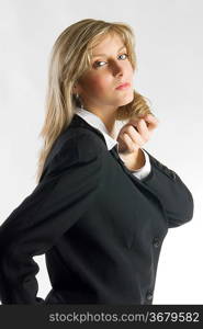 blond and attractive young woman in formal black suit making faces