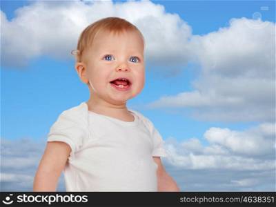 Blond baby with blue eyes with a beautiful sky of background