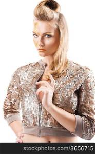 Blond beautiful creature with sequin jacket and creative make up making and hair stylish, she is turned of three quarters, looks in to the lens and her left hand is near the chest