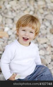 Blond boy smiling portrait on a rolling stones background