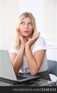 Blond businesswoman doing funny faces in the office