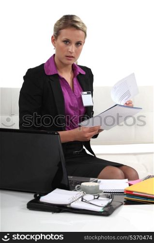 Blond businesswoman sat with report