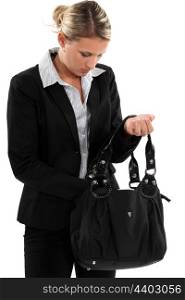 Blond businesswoman searching through her bag