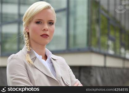 Blond businesswoman stood outside building