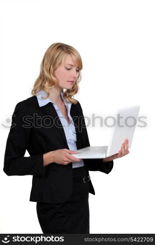Blond businesswoman stood with laptop