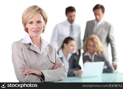 Blond businesswoman with colleagues in background