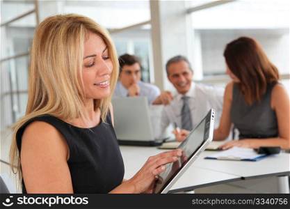 Blond businesswoman working on electronic tab