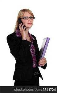 Blond businesswomen with folder and mobile
