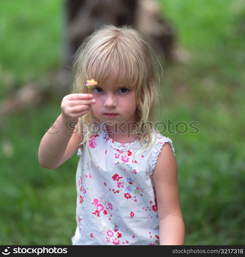 Blond Child Holding Flower Up to Camera at Moorea in Tahiti