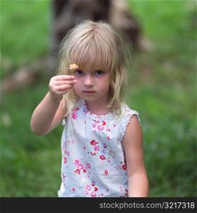 Blond Child Holding Flower Up to Camera at Moorea in Tahiti