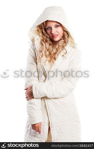 Blond curly haired woman wearing a white winter jacket with a hood making face and enjoing over white, her right hand takes left elbow