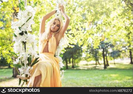 Blond cutie swinging on the ornamented seesaw