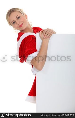 Blond dressed in Santa outfit stood with message board