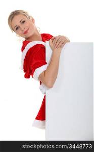 Blond dressed in Santa outfit stood with message board